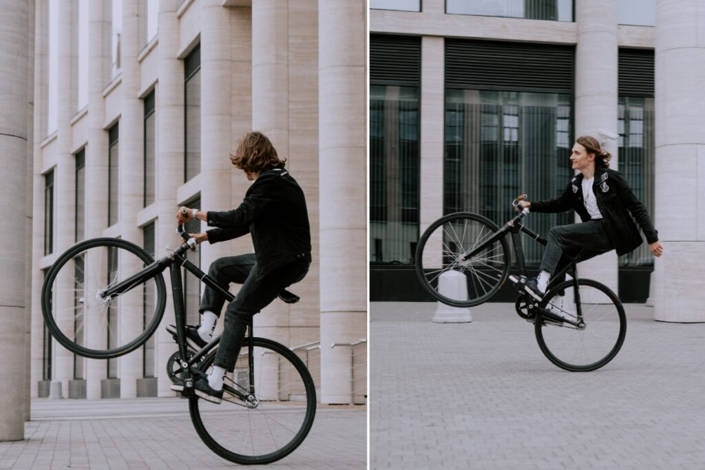 Guy popping a wheelie on bicycle